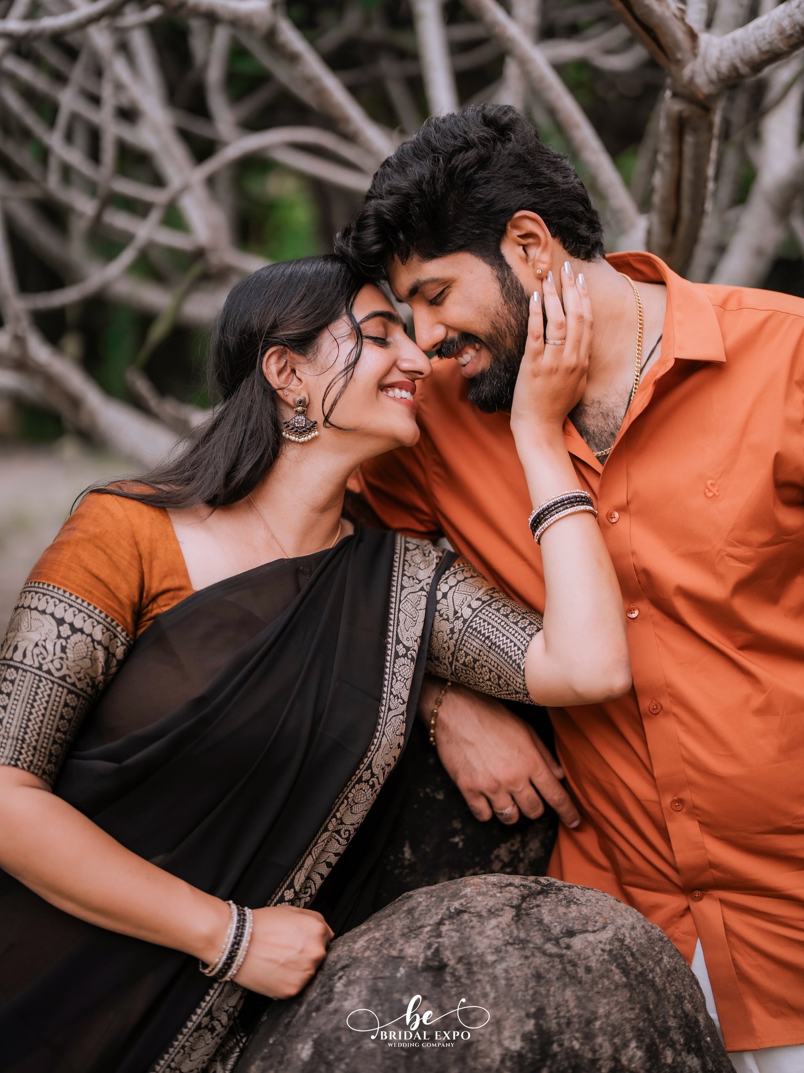 An affectionate couple embracing against a natural stone setting